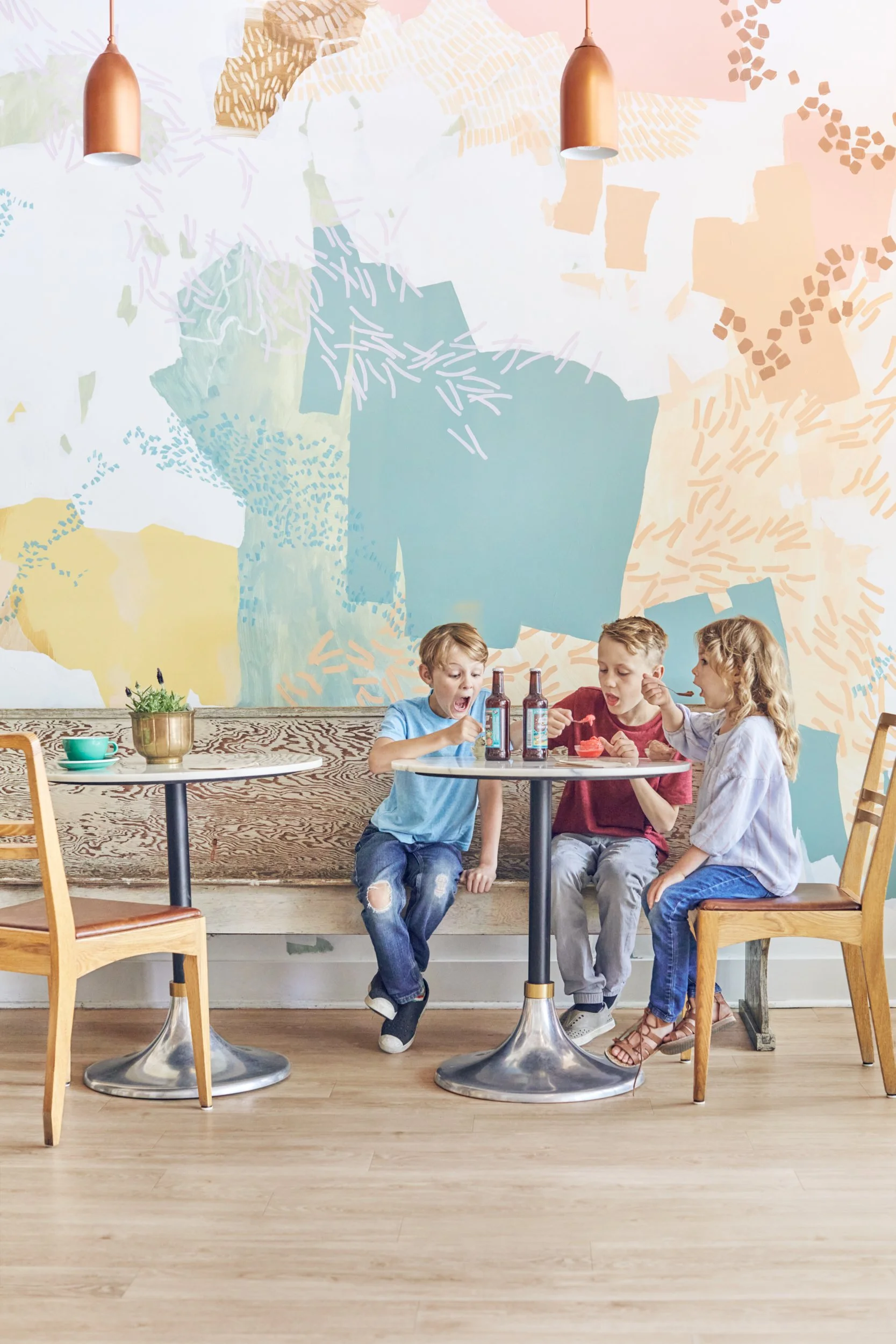 Kids eating gelato at bistro table in gelato shop.