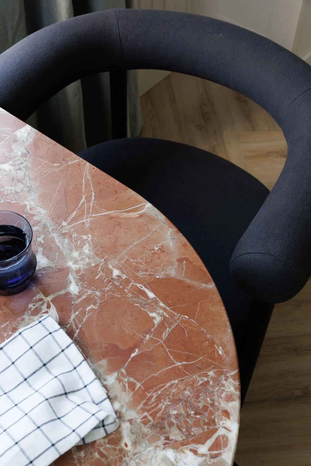Marble rounded table with chair and glass of water.