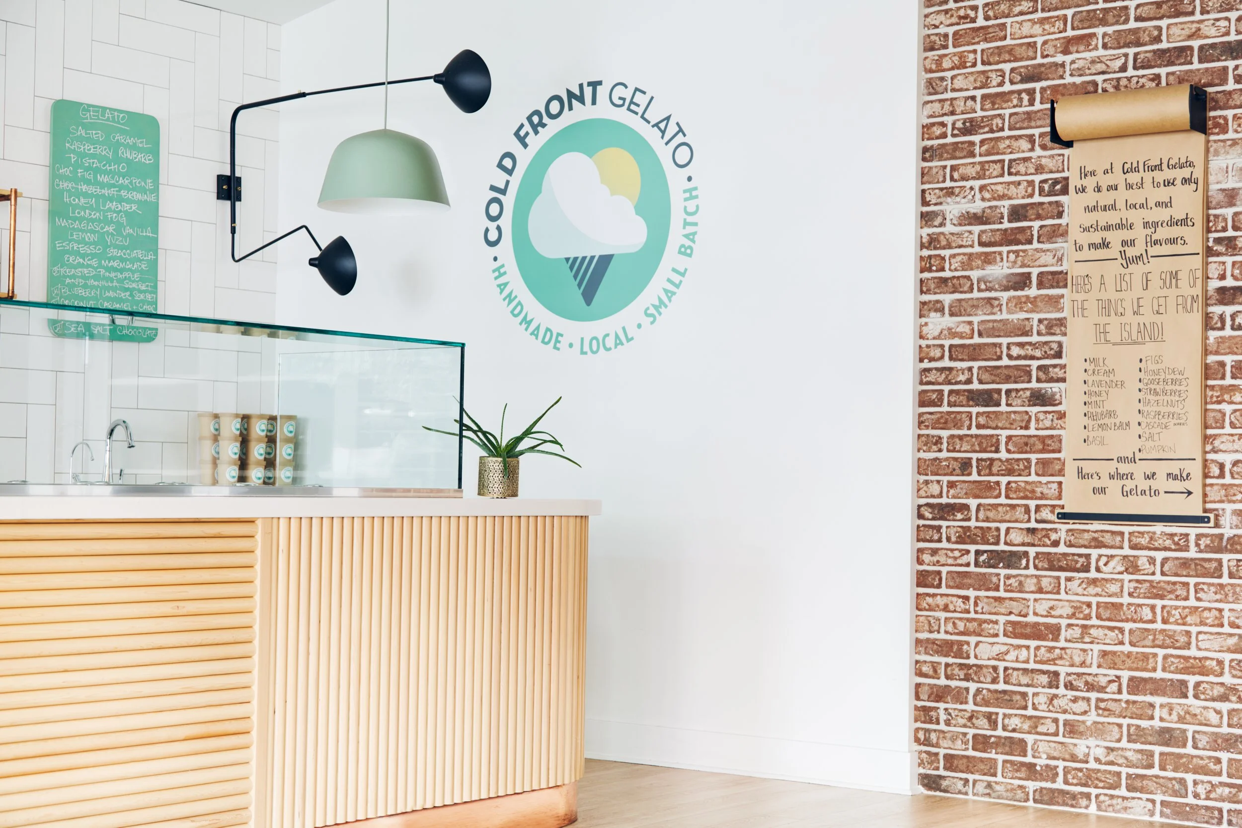 Gelato service counter with textural wood detail, brick wall and large Cold Front Logo.