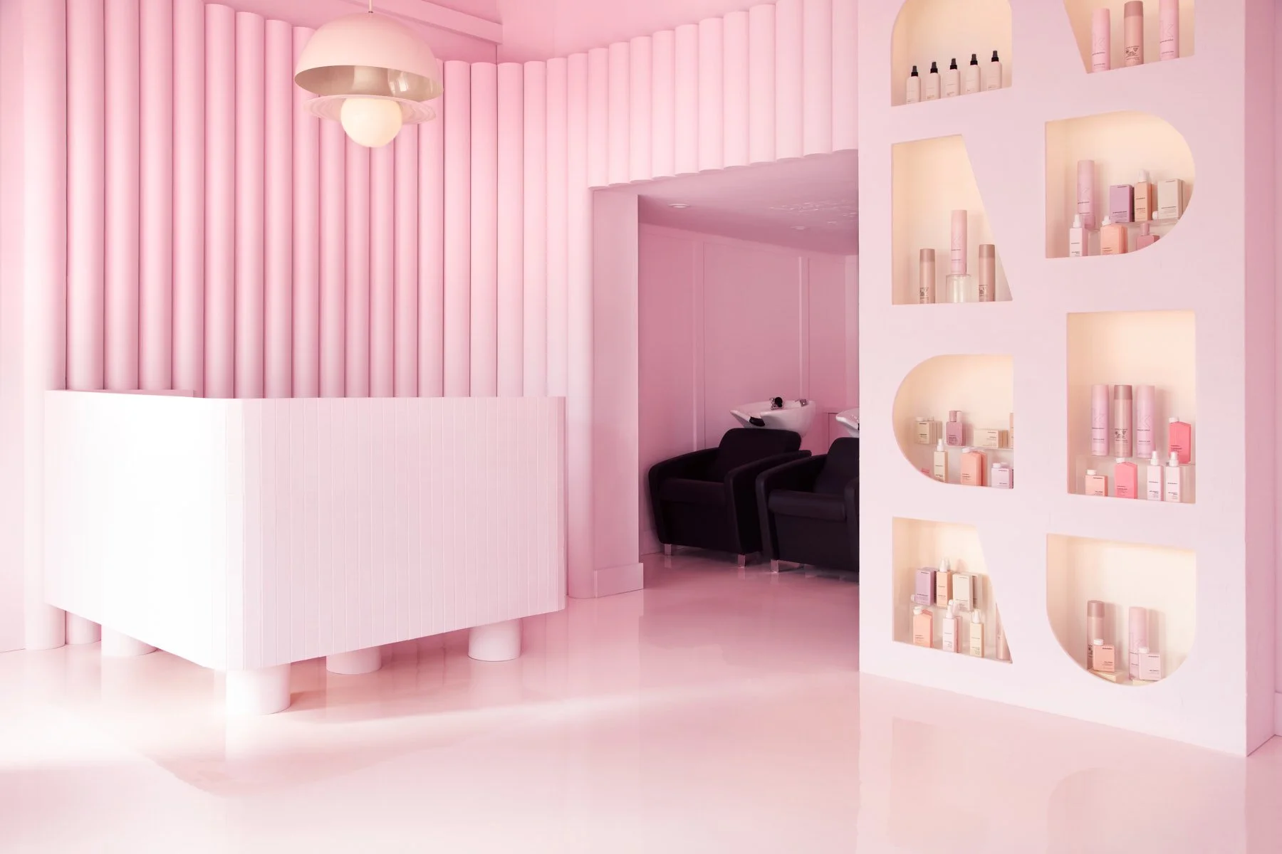 Overall view of the Pink Label hair salon front desk and merchandise shelving unit
