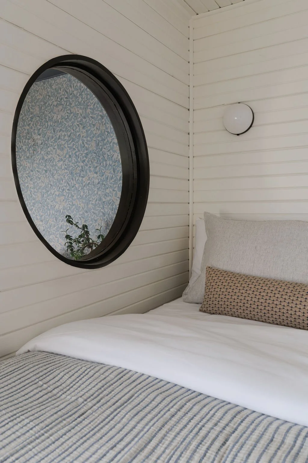 Loft bed with large round window.