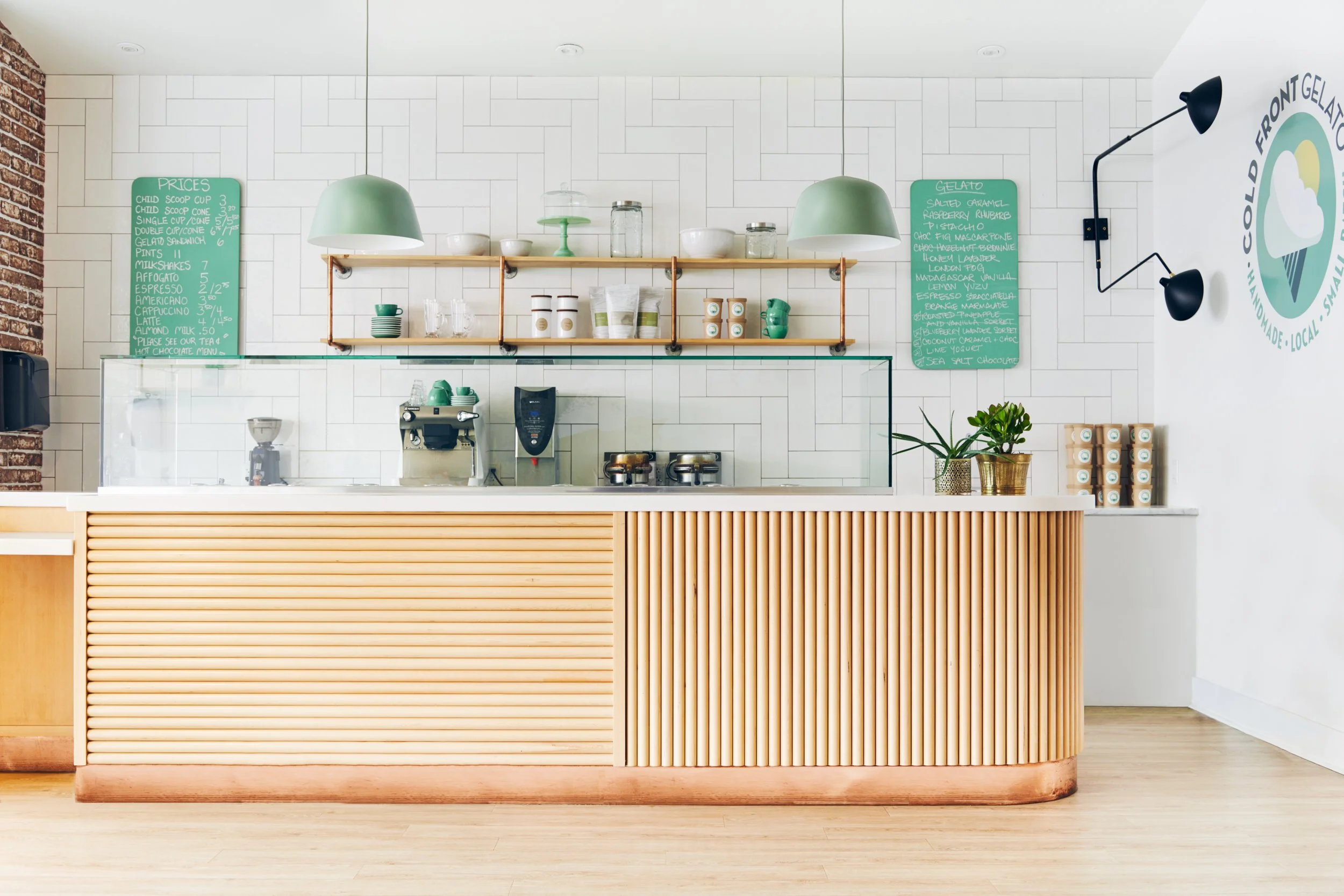 Photo of gelato counter and shelving and menus behind counter.