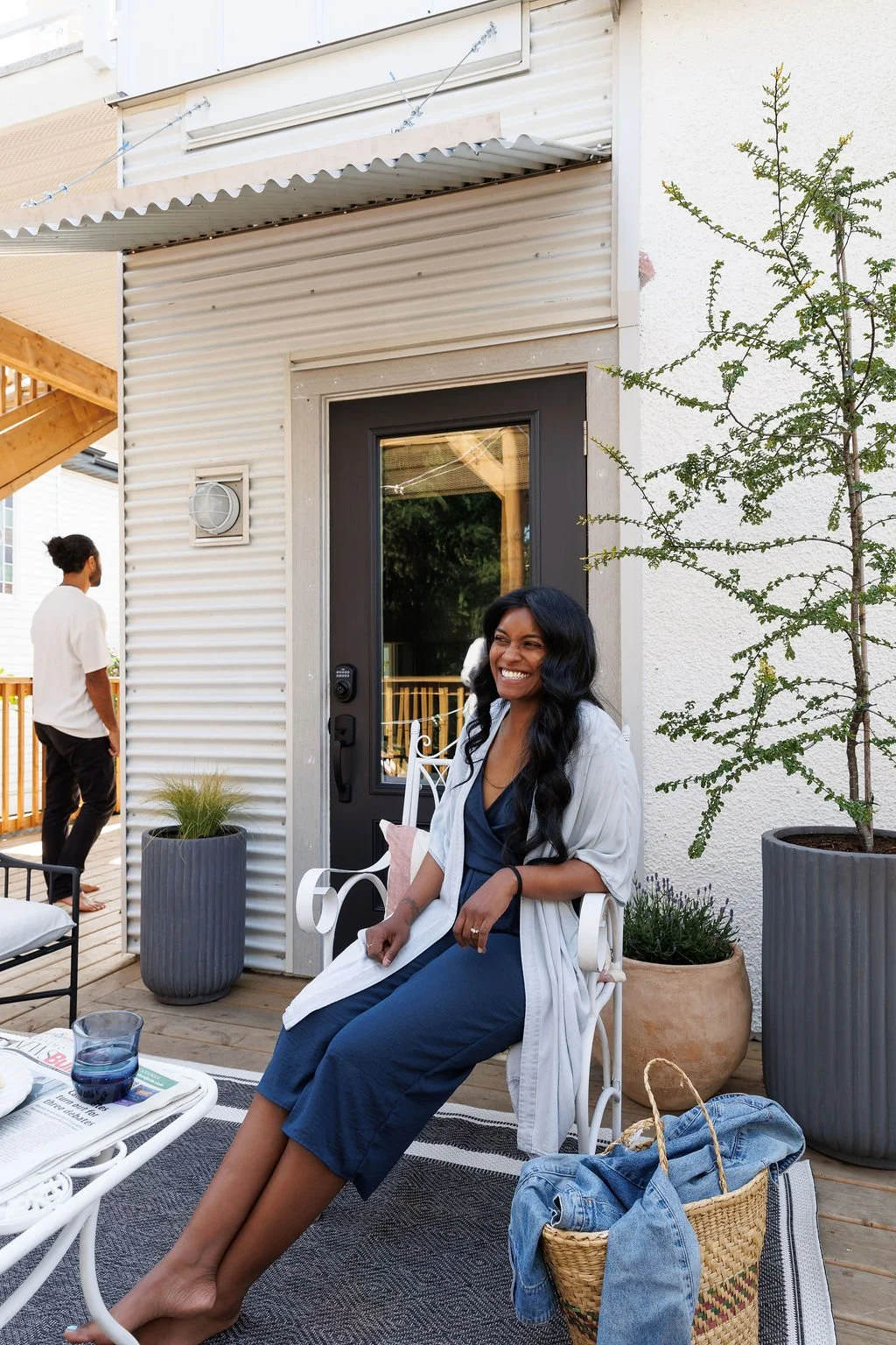 Siya smiling while sitting on an iron chair on the Selby Hotel back deck on a sunny day.