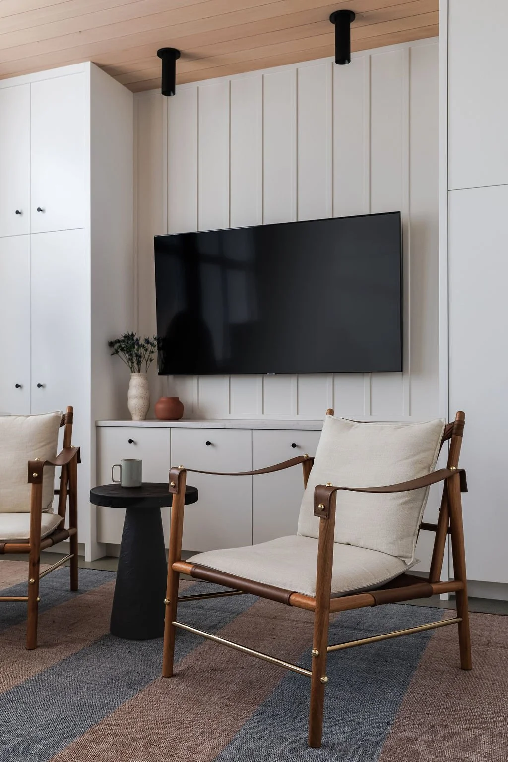 Photo of relaxed chairs in front of built in cabinetry. 