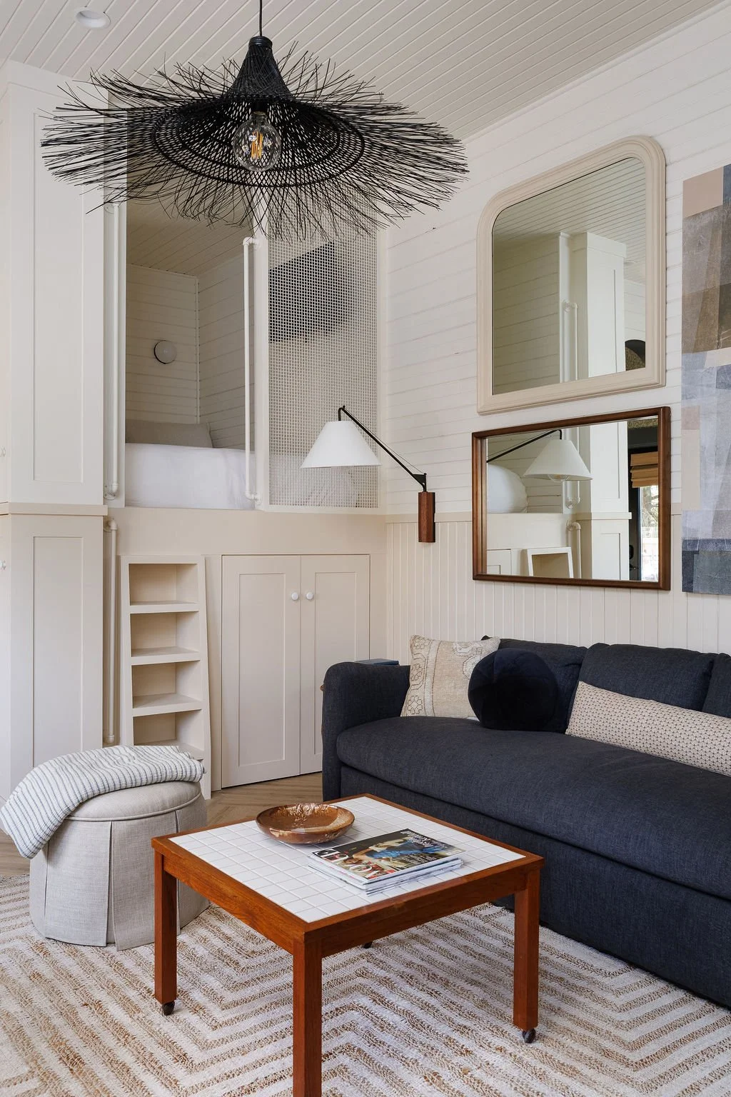 Selby Hotel living area with sofa bed, art on wall above and loft bed.