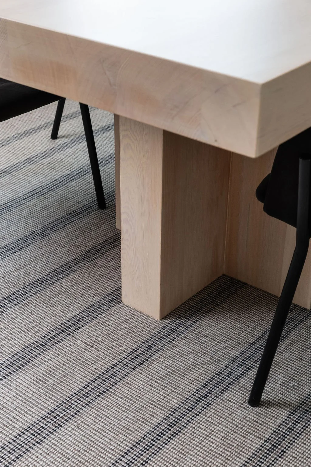 Photo of timber boardroom table detail on stripped rug.