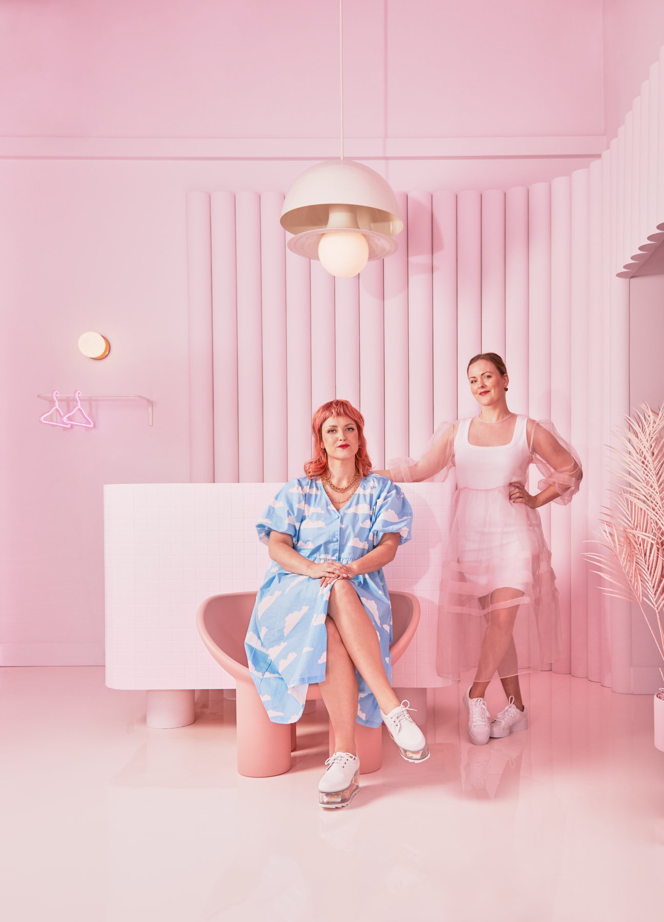 Pink Label hair salon owner Chantel Cody and interior designer Alana Dick pose in front of hair salon front desk.
