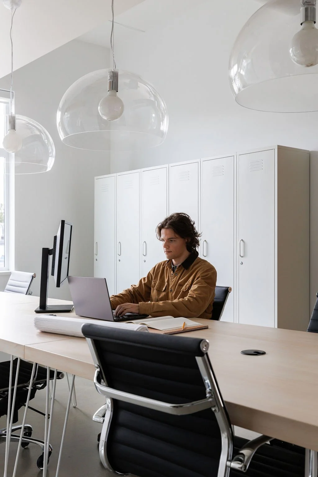 Photo of man sitting at desk, working on laptop computer. 