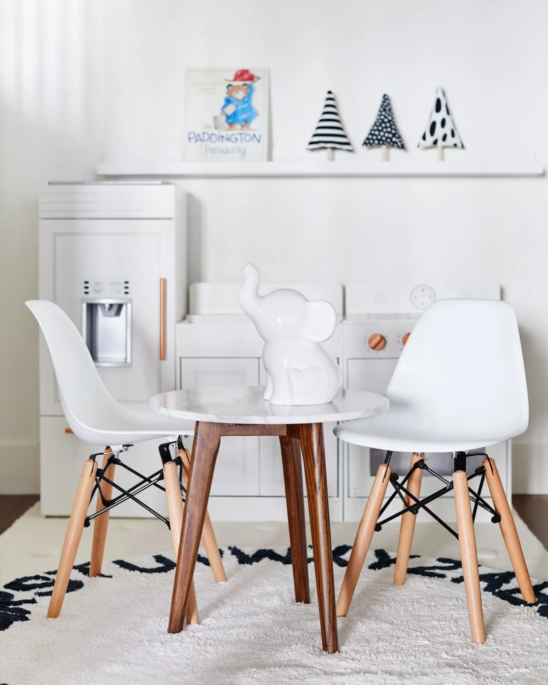 Close-up photo of kids bistro table in front of kids kitchen, decor and books.
