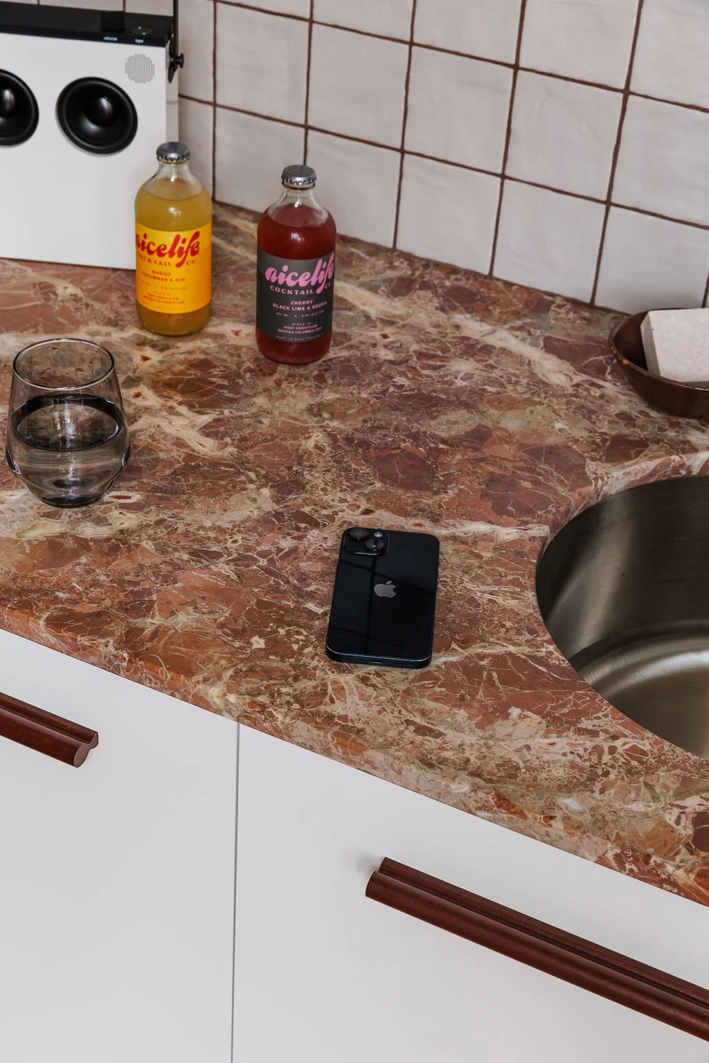 Selby office coffee bar marble counter with iPhone and drinks on counter.