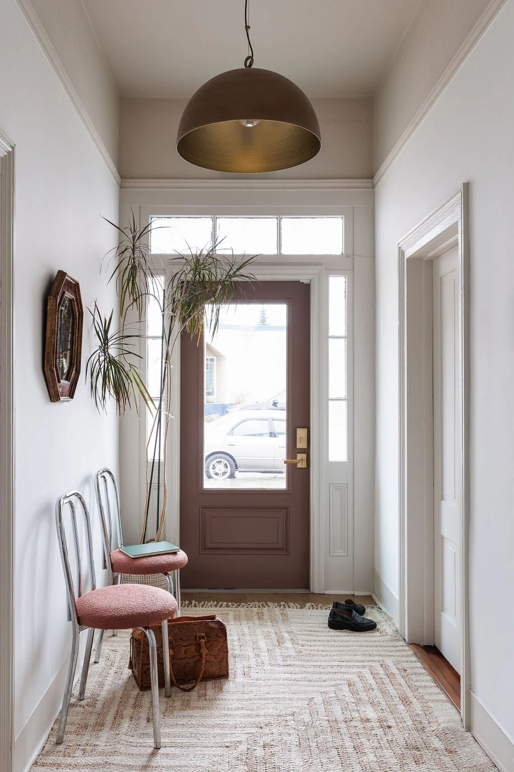 Entry at Selby office with chrome cafe chairs, heritage door with sun shining through glass.