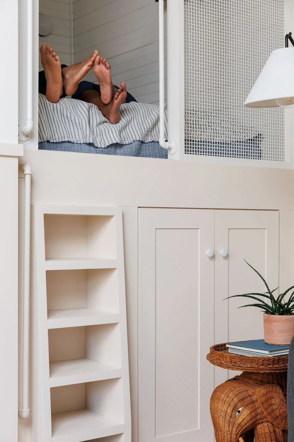 Man and woman's feet peeking out of loft bed.