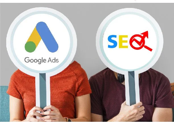 Two people holding signs in front of their faces, one with Google Ads logo and the other with SEO and target icon, representing digital marketing.