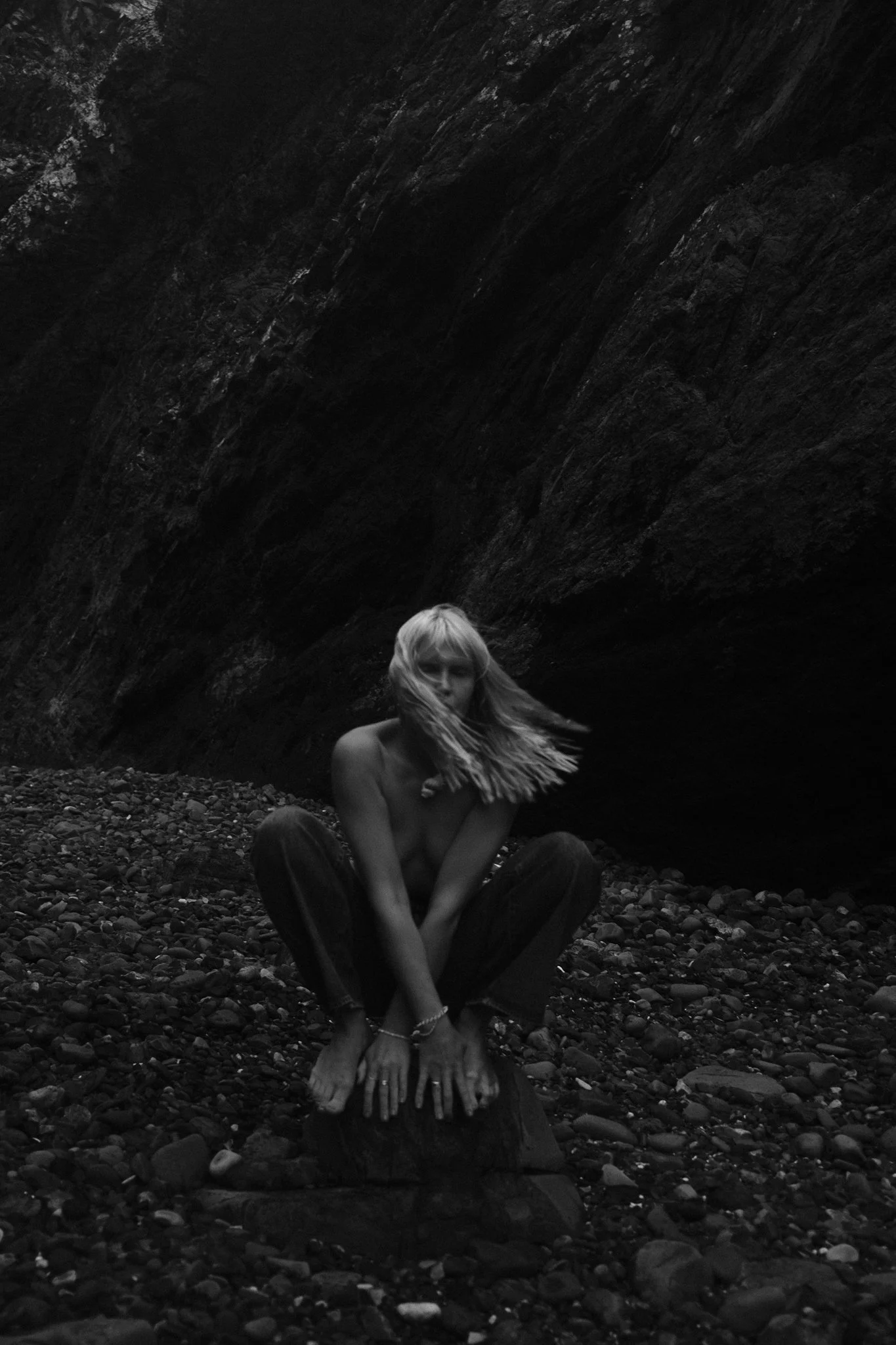 Editorial shot of Sonja Vahasaari modeling Wrangler flared jeans in a rocky location.