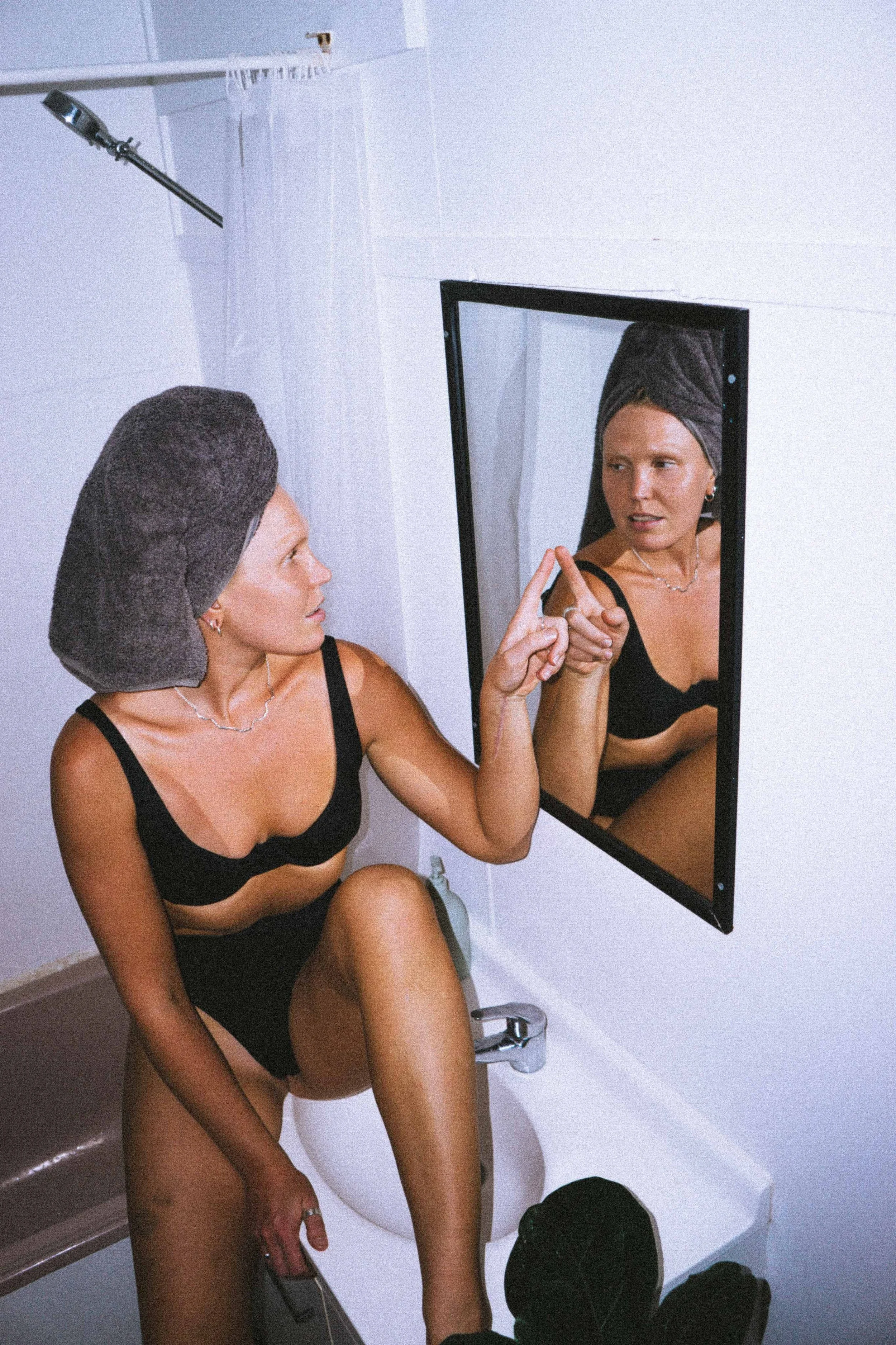 Sonja Vahasaari modeling Savari Jam sustainable swim and surfwear in a pink bathroom.