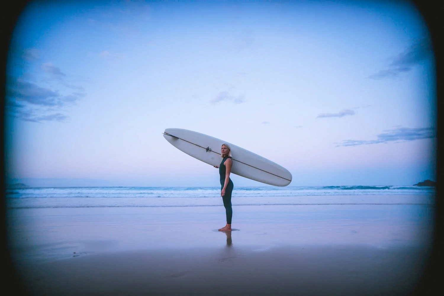Lifestyle portrait of Sonja wearing Kintana’s eco-friendly wetsuit by the beach.