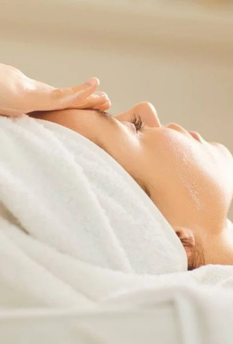 Persoon krijgt een gezichtsmassage in een wellnesscentrum of spa.