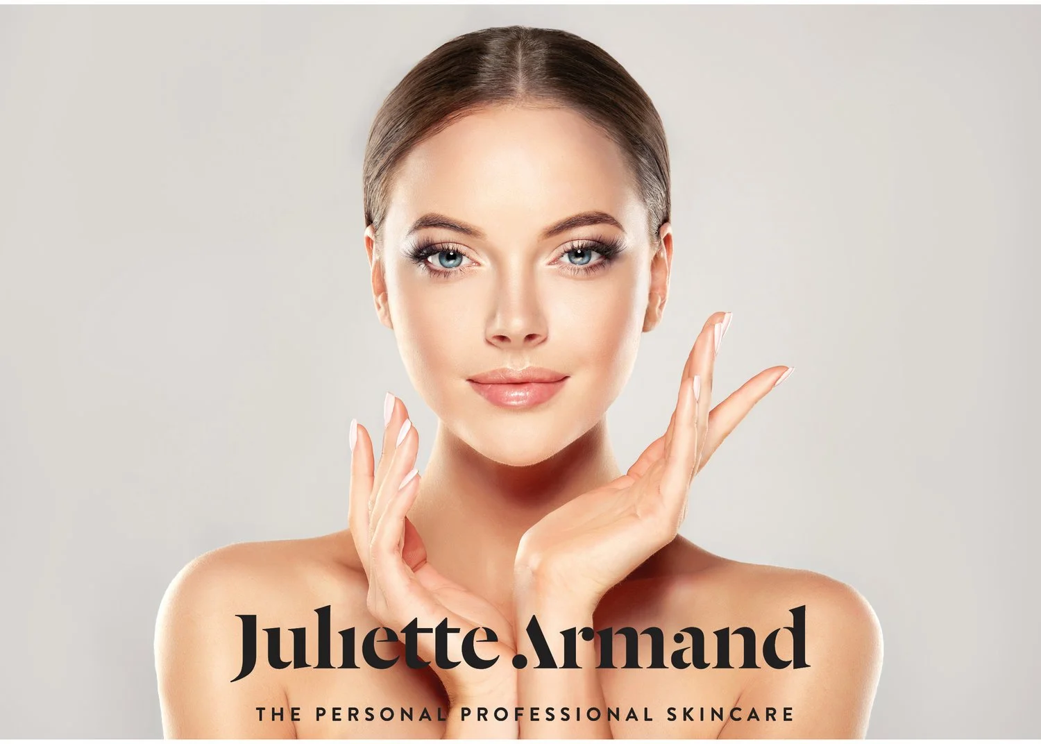 Portret van een jonge vrouw met gladde huid, lichte make-up en lichte blauwe ogen, met haar handen opgeheven bij haar gezicht, tegen een lichte achtergrond, tekst over haar met de naam 'Julette Armand' en de slogan 'The Personal Professional Skincare'.