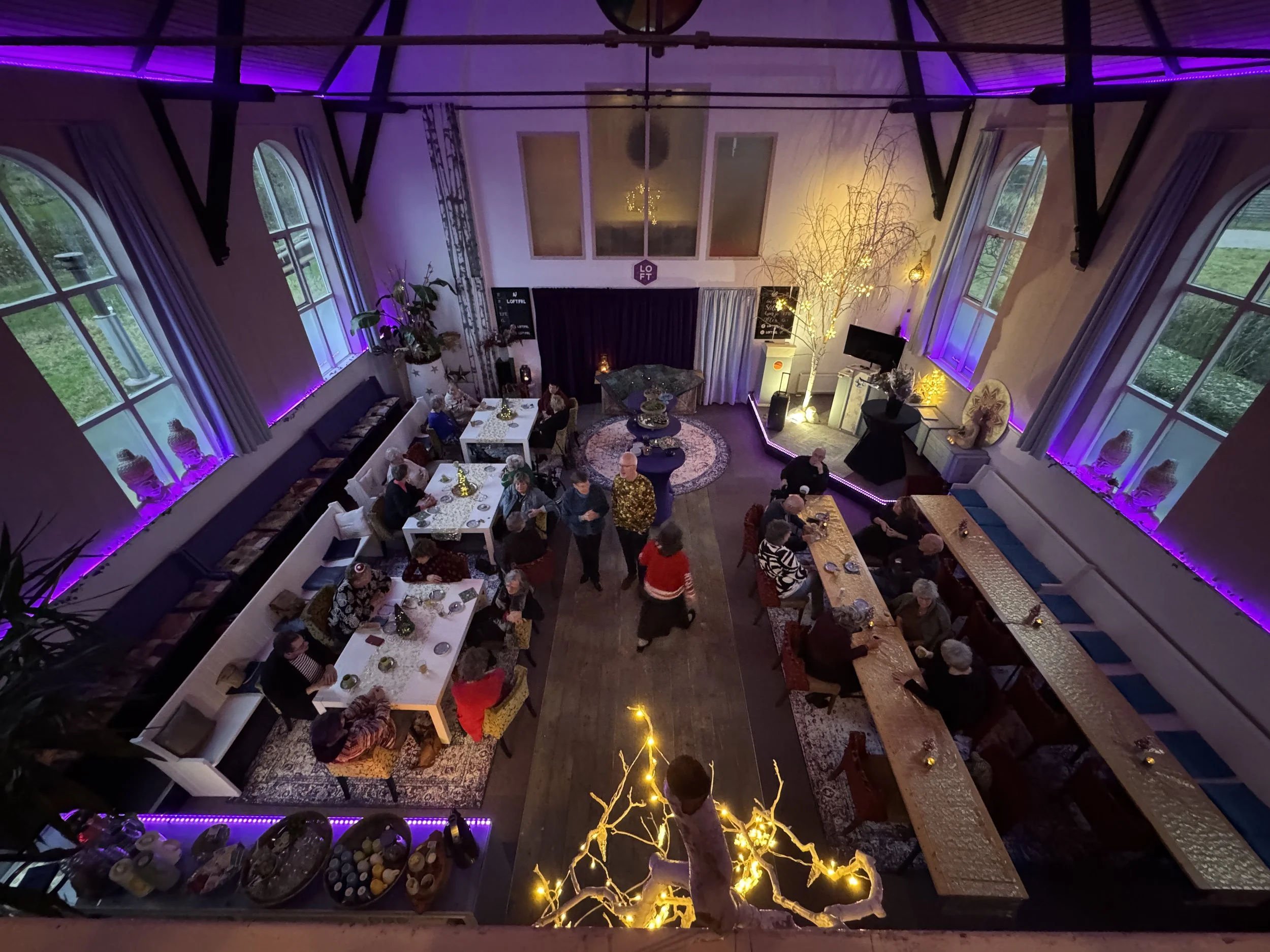 People dancing and enjoying music at a nightclub with colorful lights, wearing headphones, smiling and having fun.