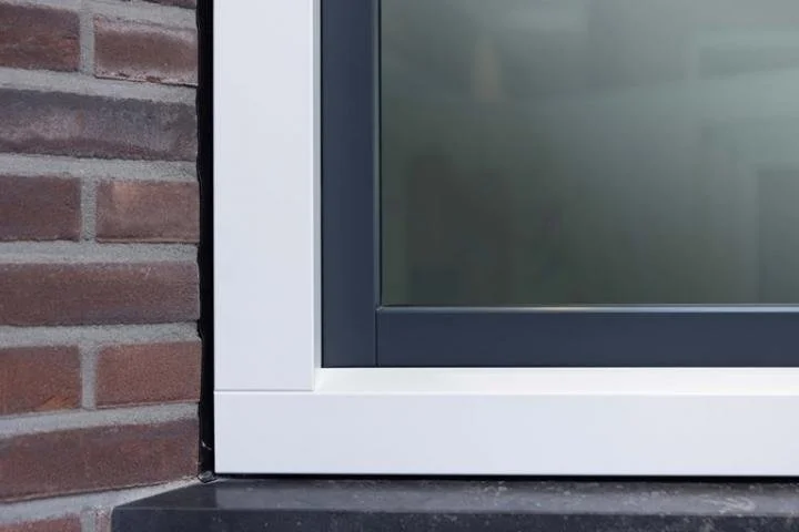 Close-up of a modern window with a black frame installed on a brick wall.