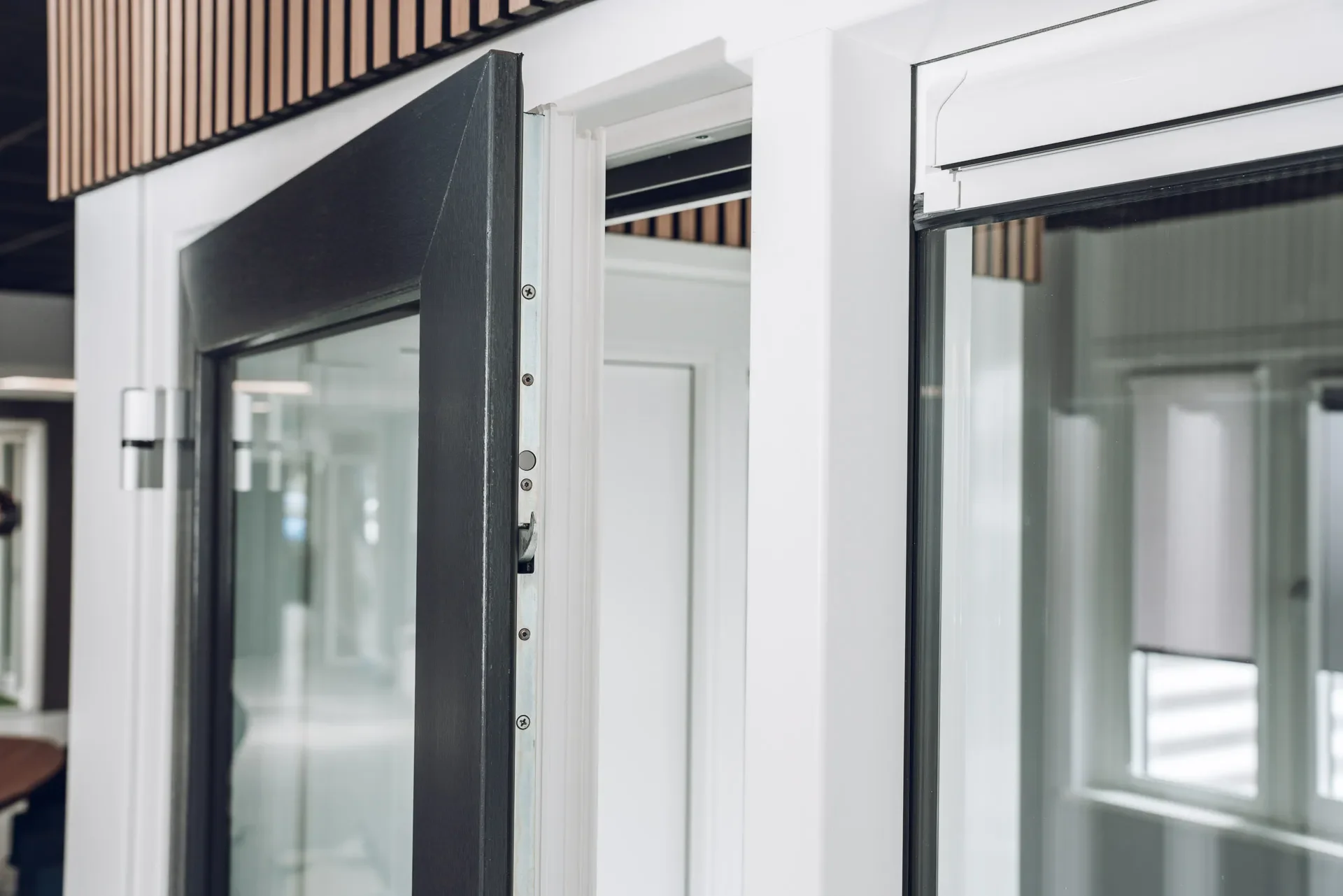 Close-up of a partially open glass door with a black frame.