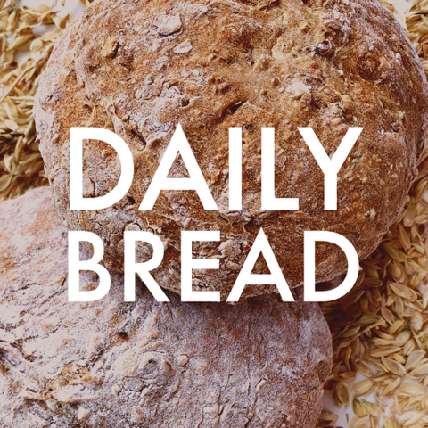 Two loaves of bread on a bed of oats with the text 'DAILY BREAD' overlaid