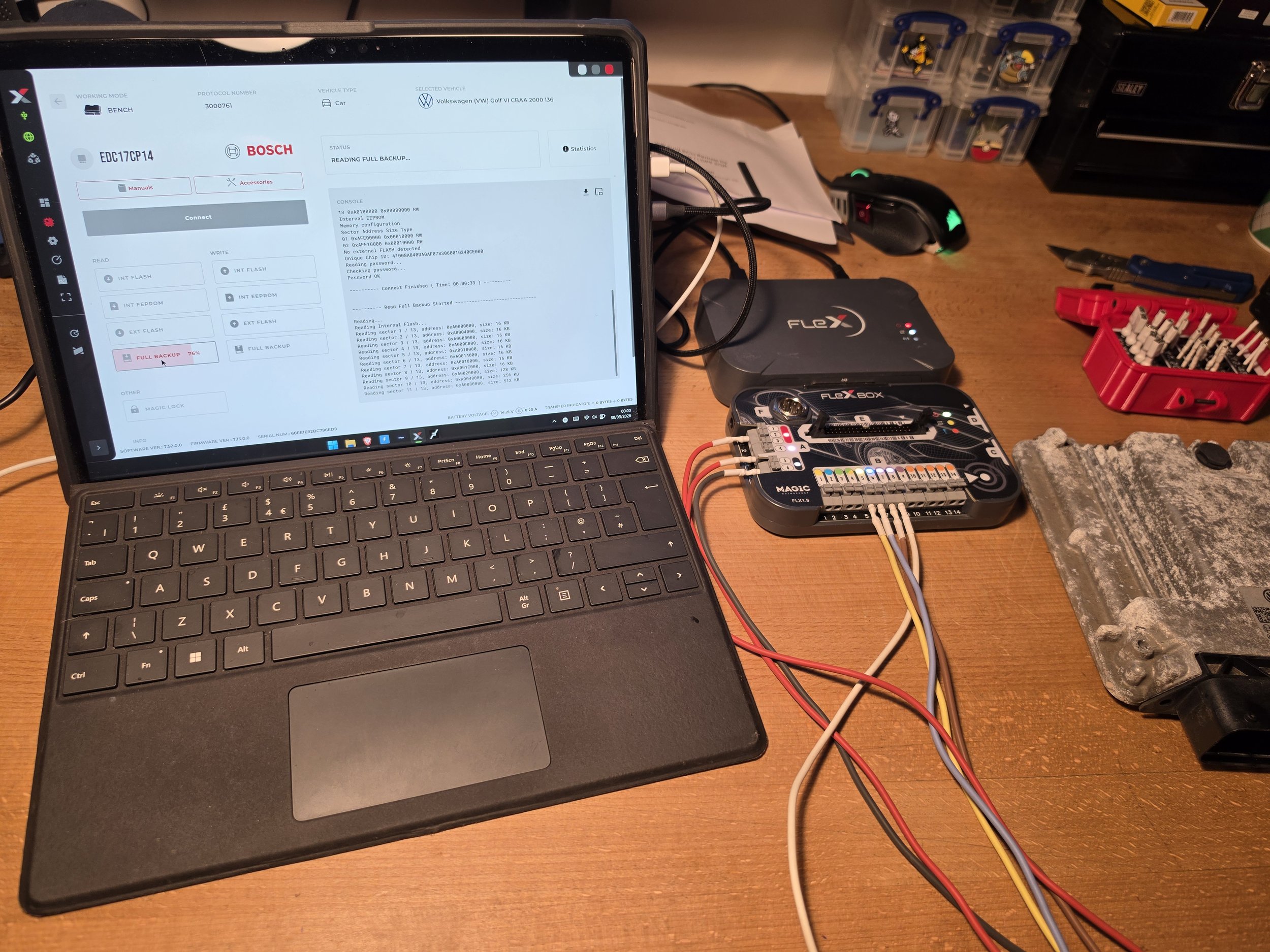 A tablet with a physical keyboard attached shows a diagnostic screen for a vehicle system, connected via various colored wires to a device on a wooden desk. Nightfall Automotive Adblue Solution