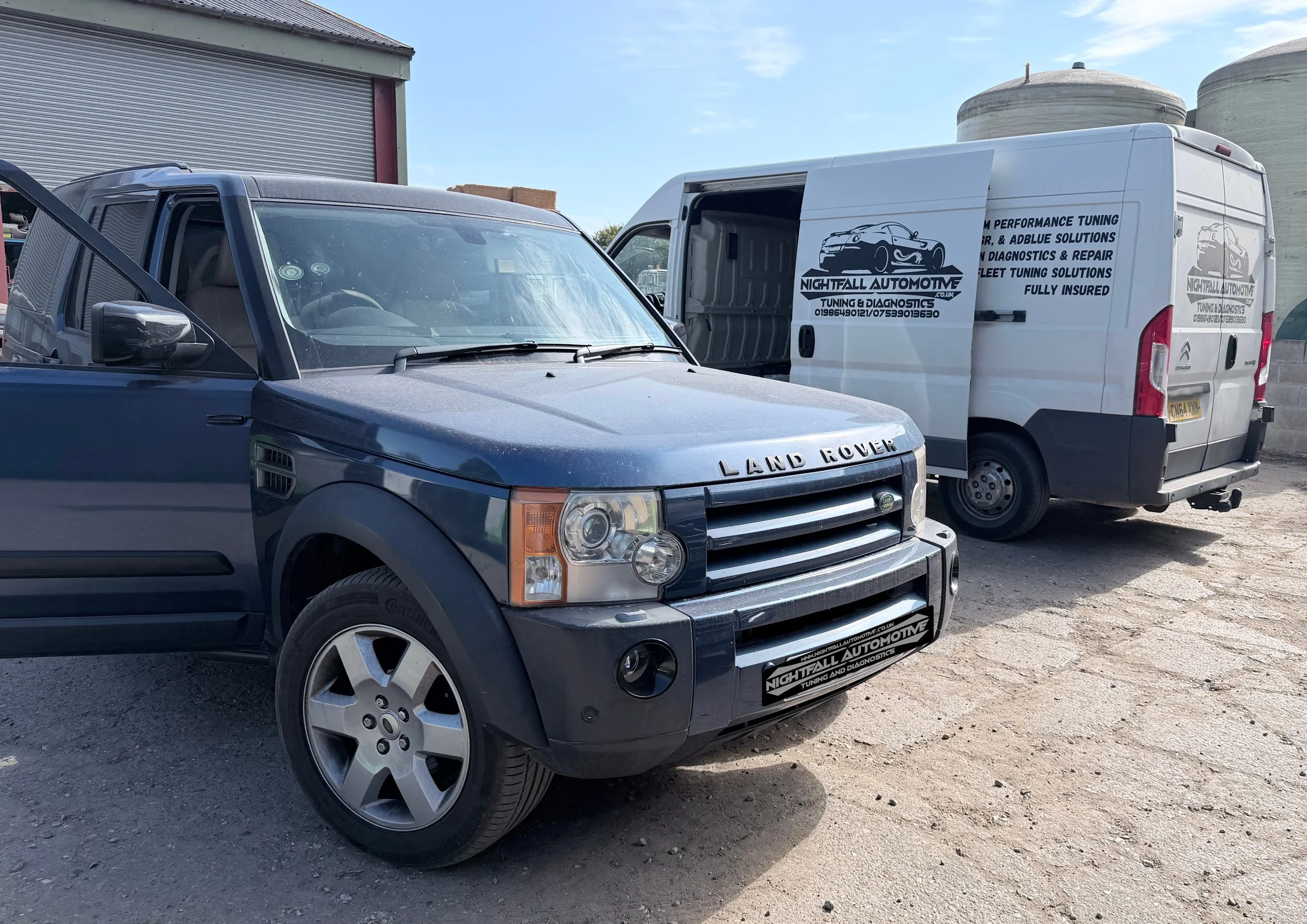 A black Land Rover parked in a lot next to a white van with logo of Nightfall Automotive and services listed, including tuning, diagnostics, and repair.
Tuned by Nightfall Automotive