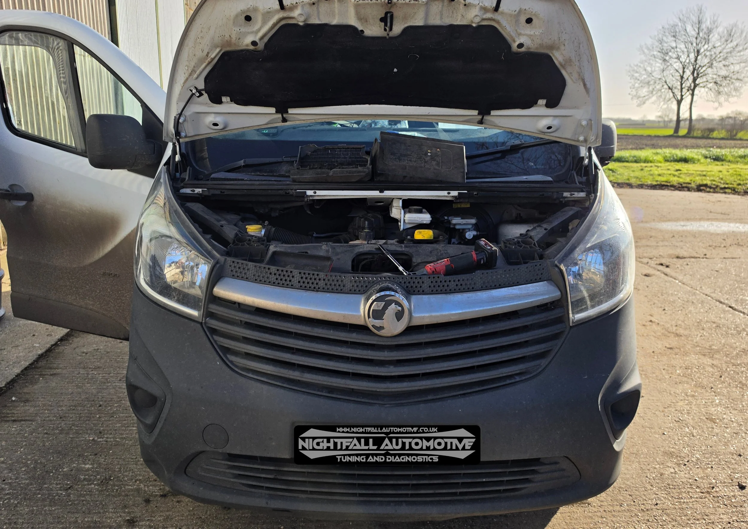 Front view of a van with its hood open, showing the engine bay and tools placed inside. Nightfall Automotive Stage 1