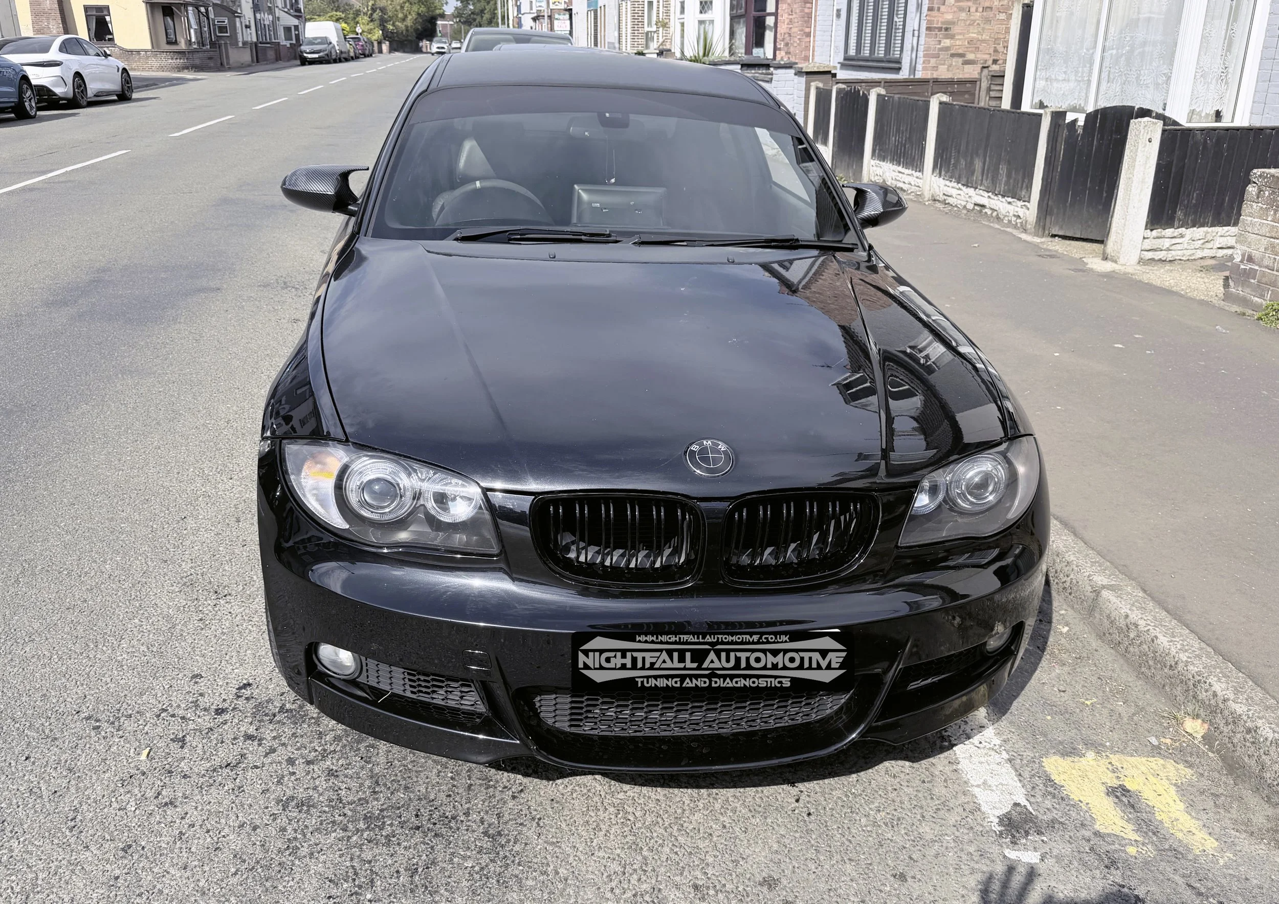 Black BMW car parked on the street with buildings and other cars in the background.
Tuned by Nightfall Automotive
