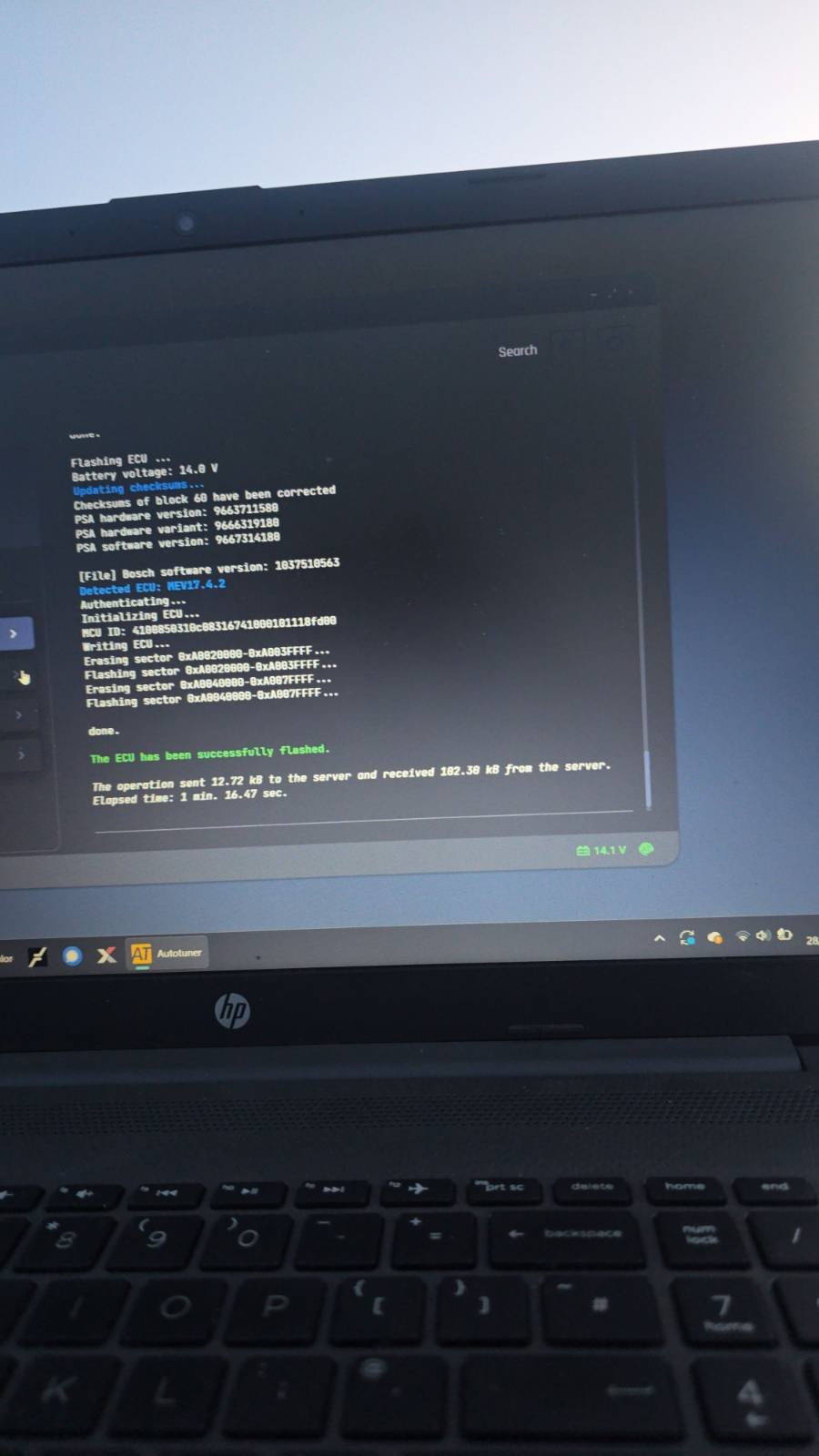 Laptop screen displaying software update and flash process for a vehicle's electronic control unit (ECU), with progress and status messages