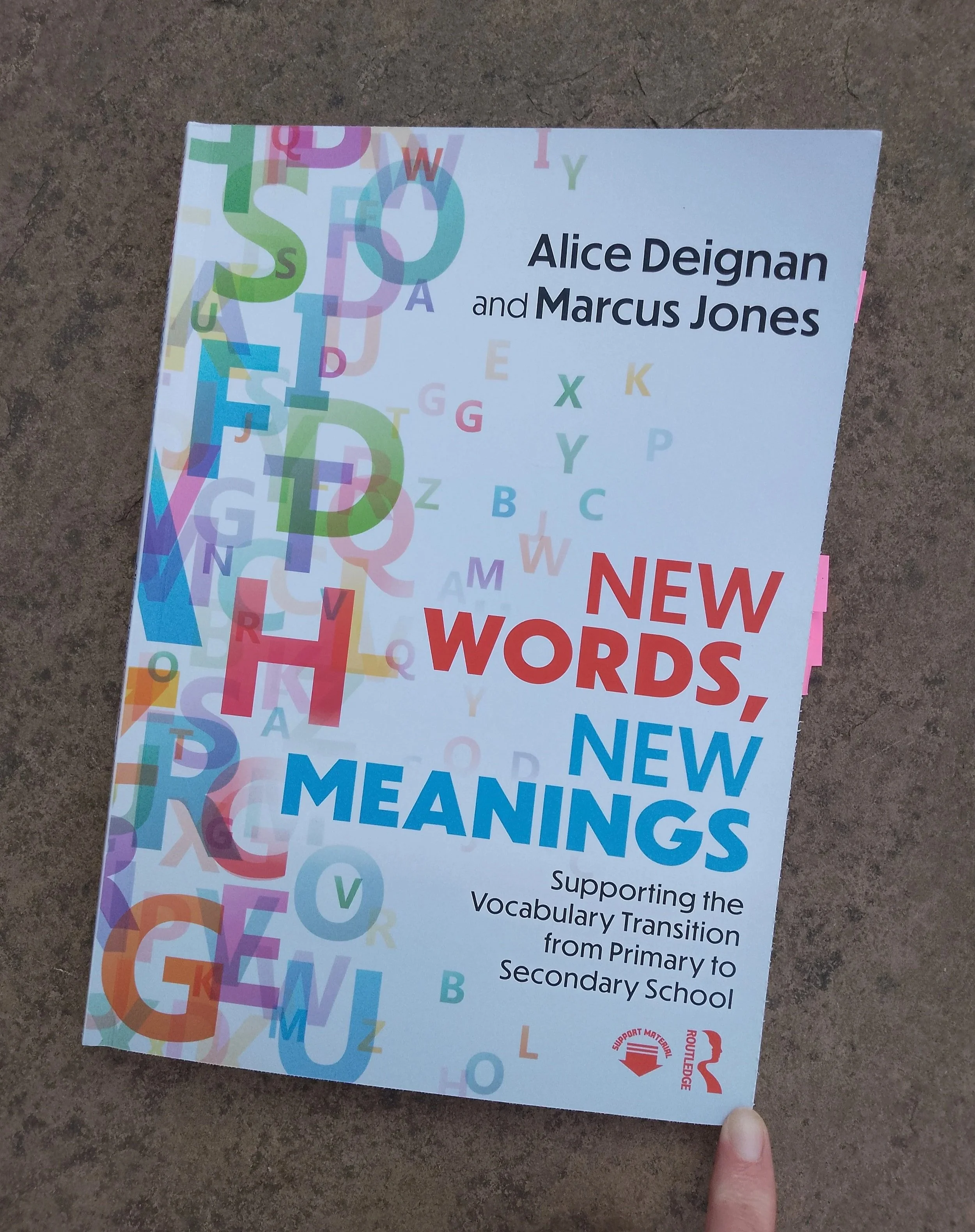 The front cover of New Words, New Meanings by Alice Deignan and Marcus Jones, subtitled Supporting the Vocabulary Transition from Primary to Secondary School. It shows a white background with coloured letters overlaid.