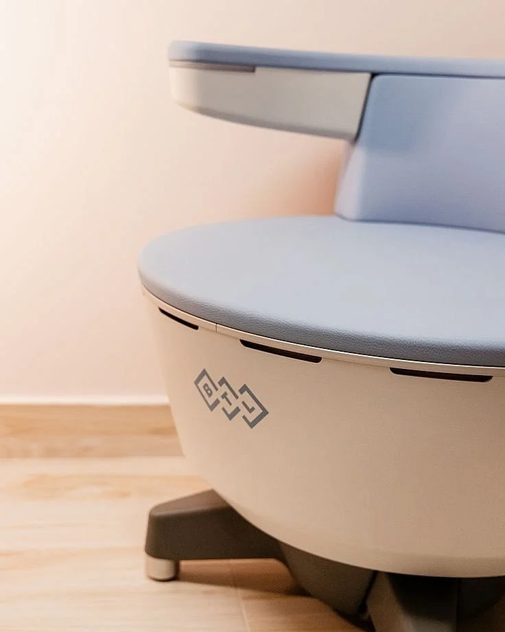 Woman receiving an Emsella pelvic floor treatment while fully clothed