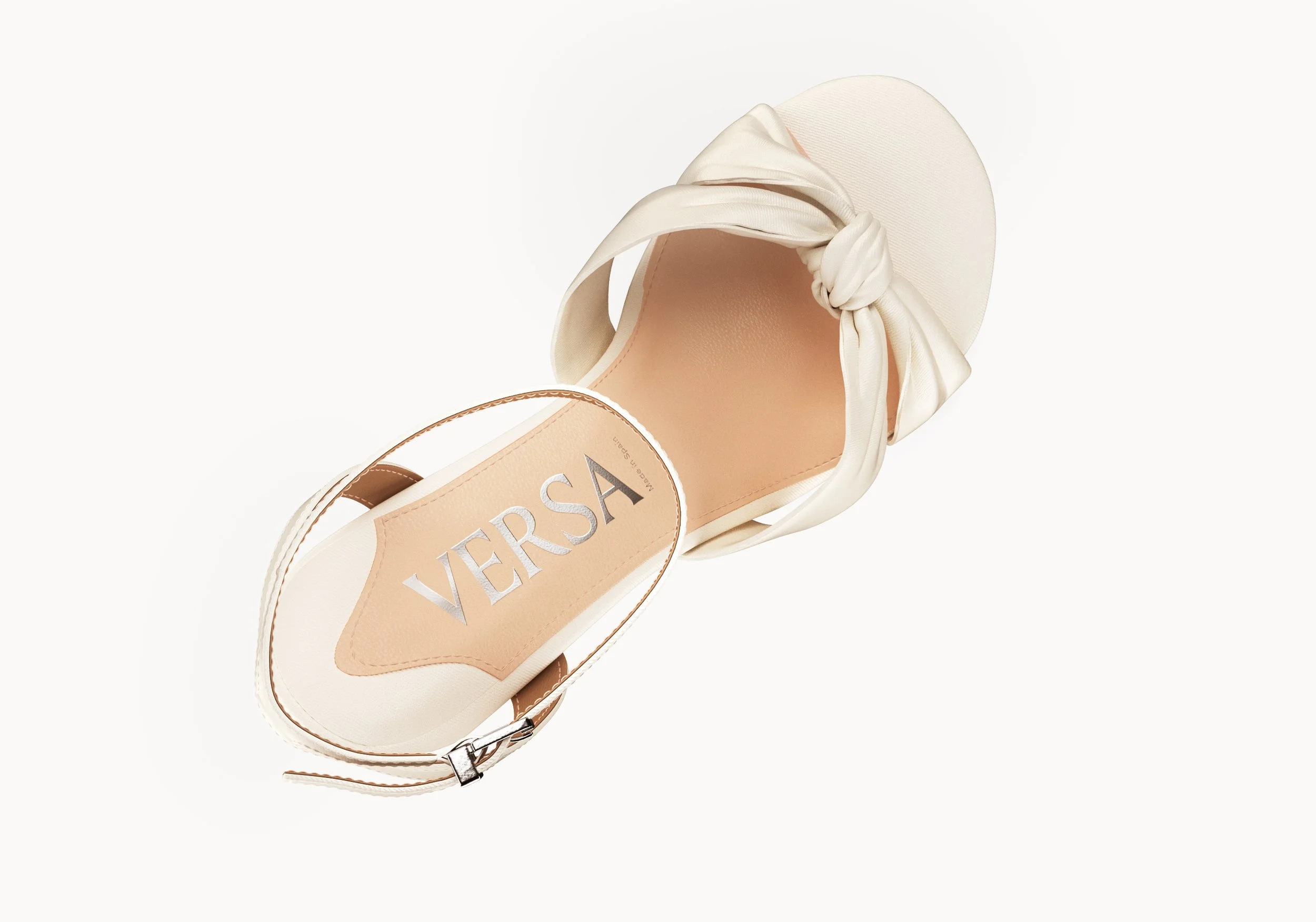 Cream-colored platform sandal with a knotted satin bow strap and a label that reads 'VERSA' on the insole.