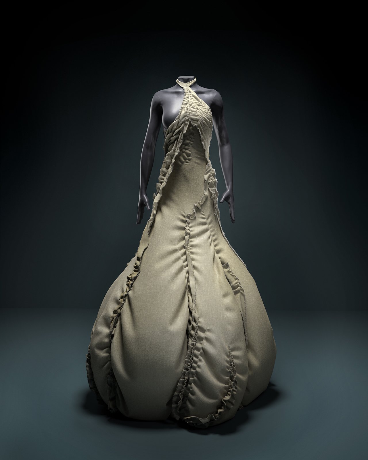 Fashion dress on a mannequin, beige fabric with ruffle details, in a dark setting.