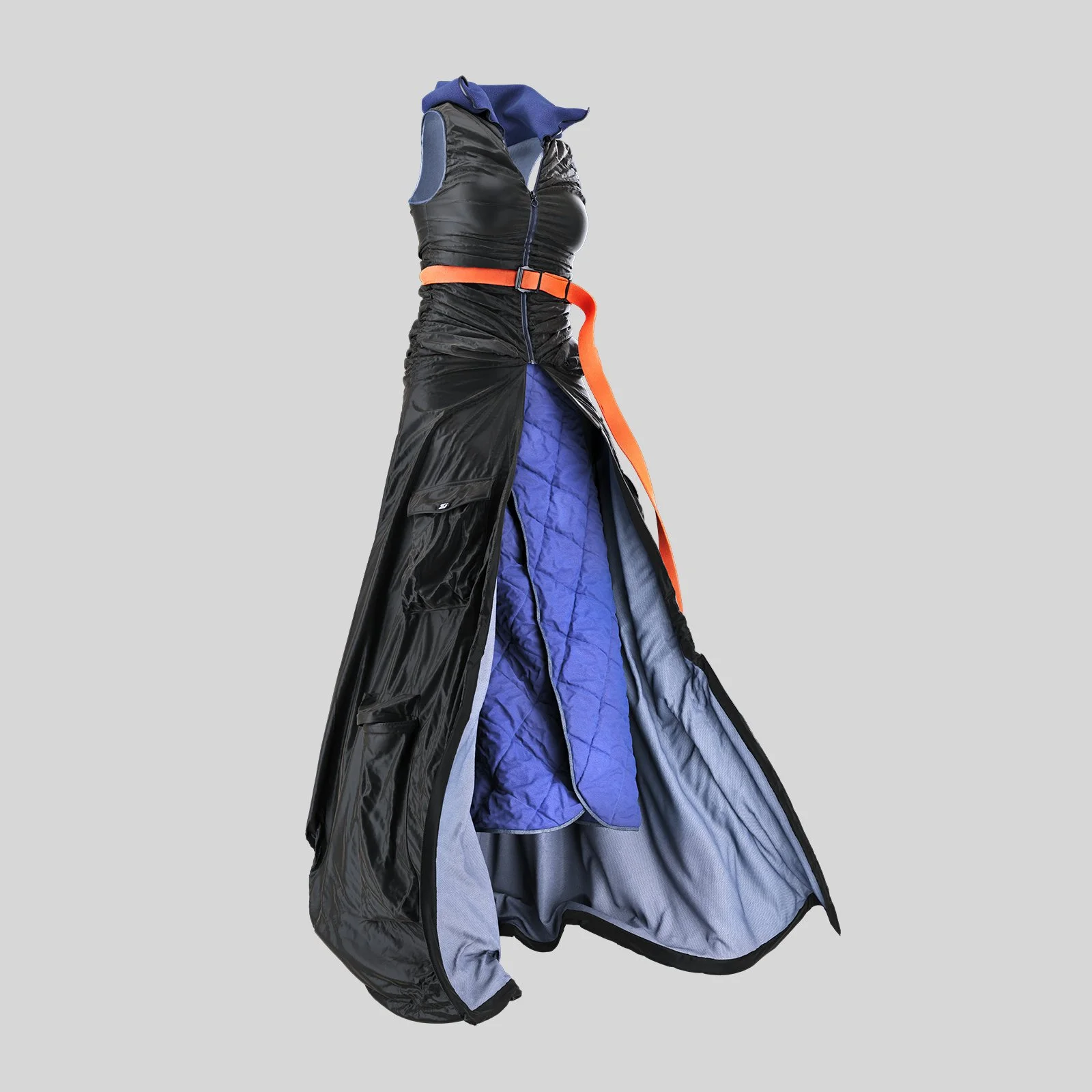 A mannequin dressed in the outer layers of a futuristic space suit, with the inner layers, including a blue quilted lining, visible from the partially unzipped exterior.