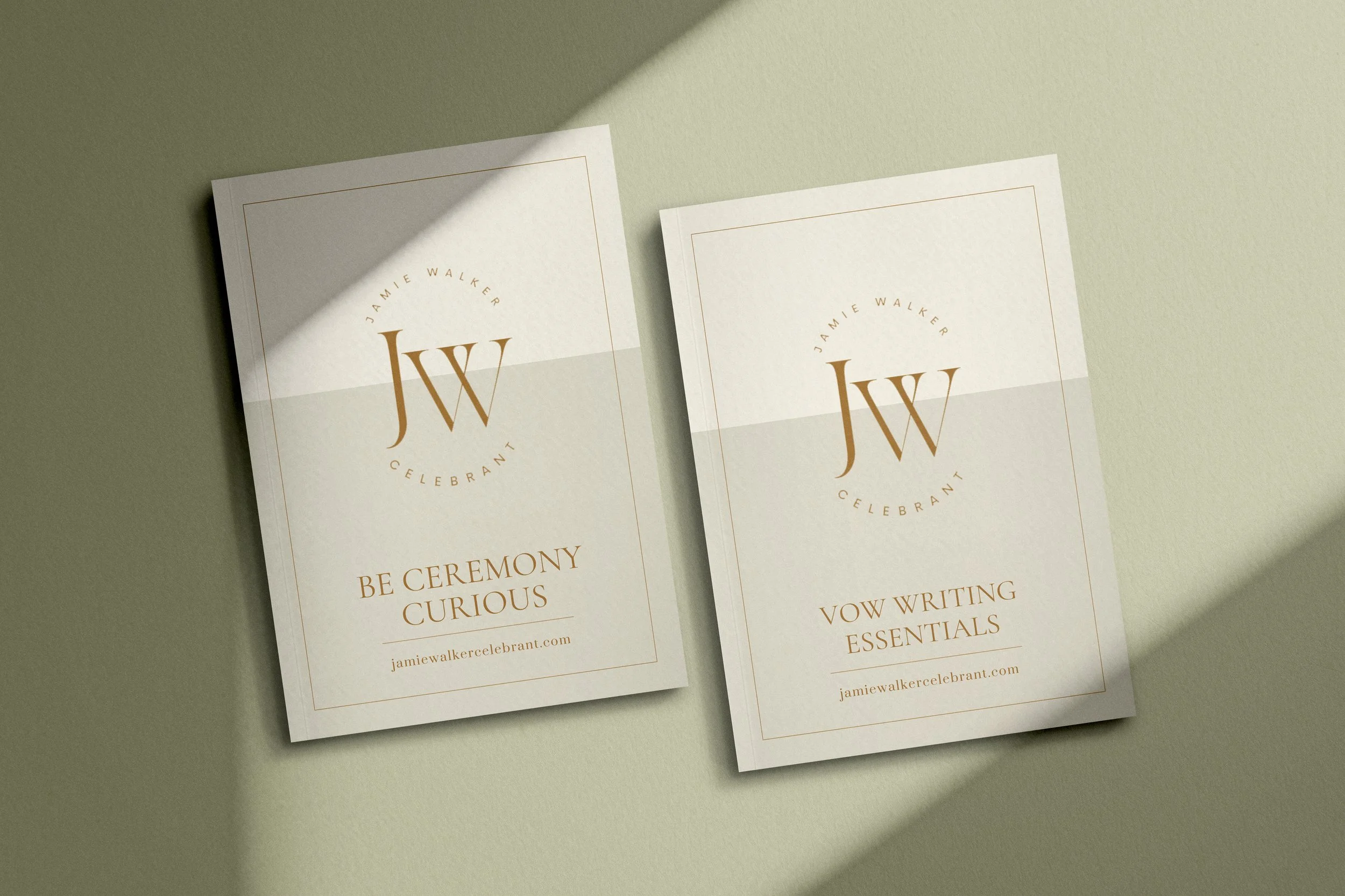 Two white booklets with gold lettering and logo on a light green surface, one titled 'Be Ceremony Curious' and the other 'Vow Writing Essentials' by Jamie Walker Celebrant.