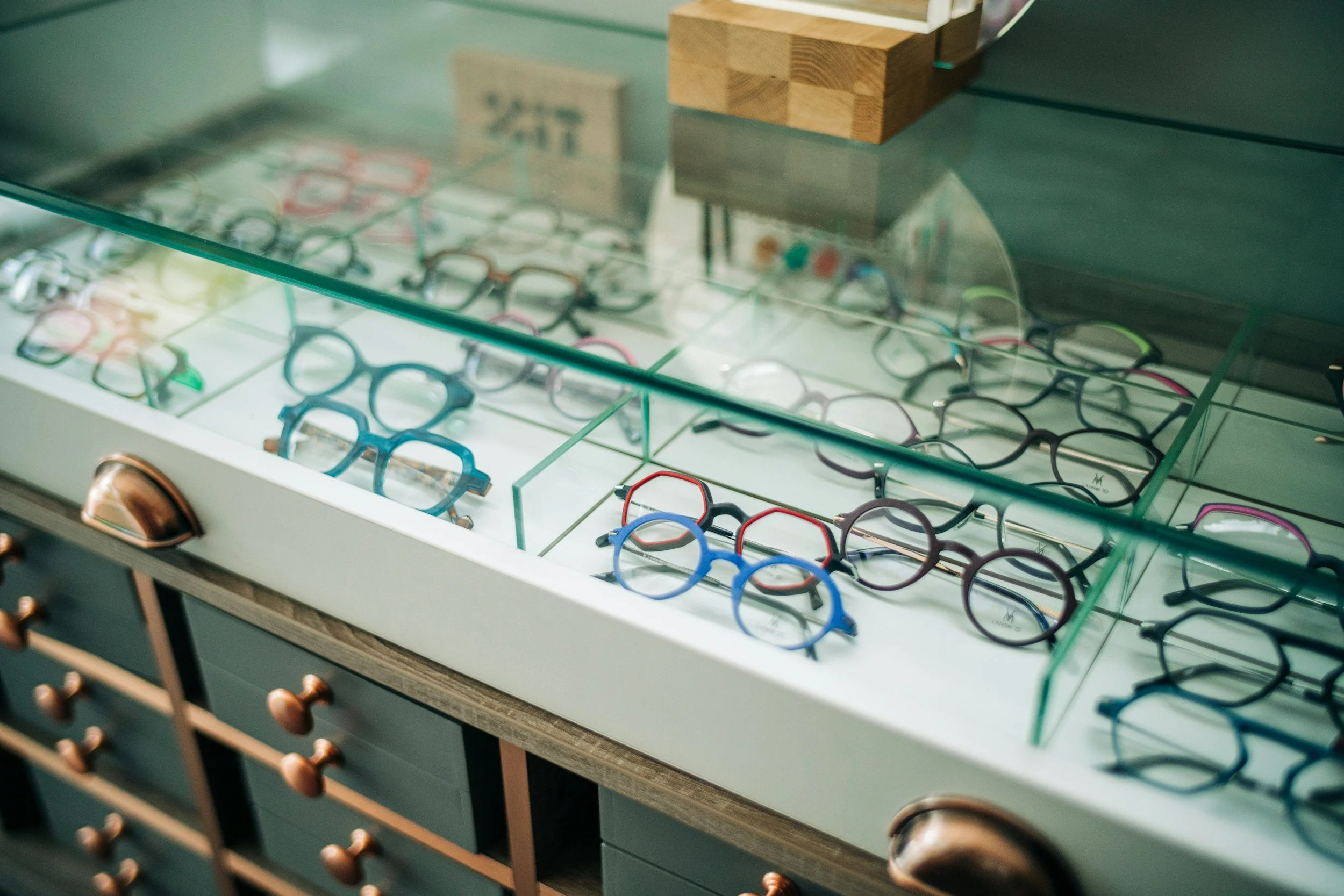 Display case with multiple pairs of glasses and sunglasses inside.