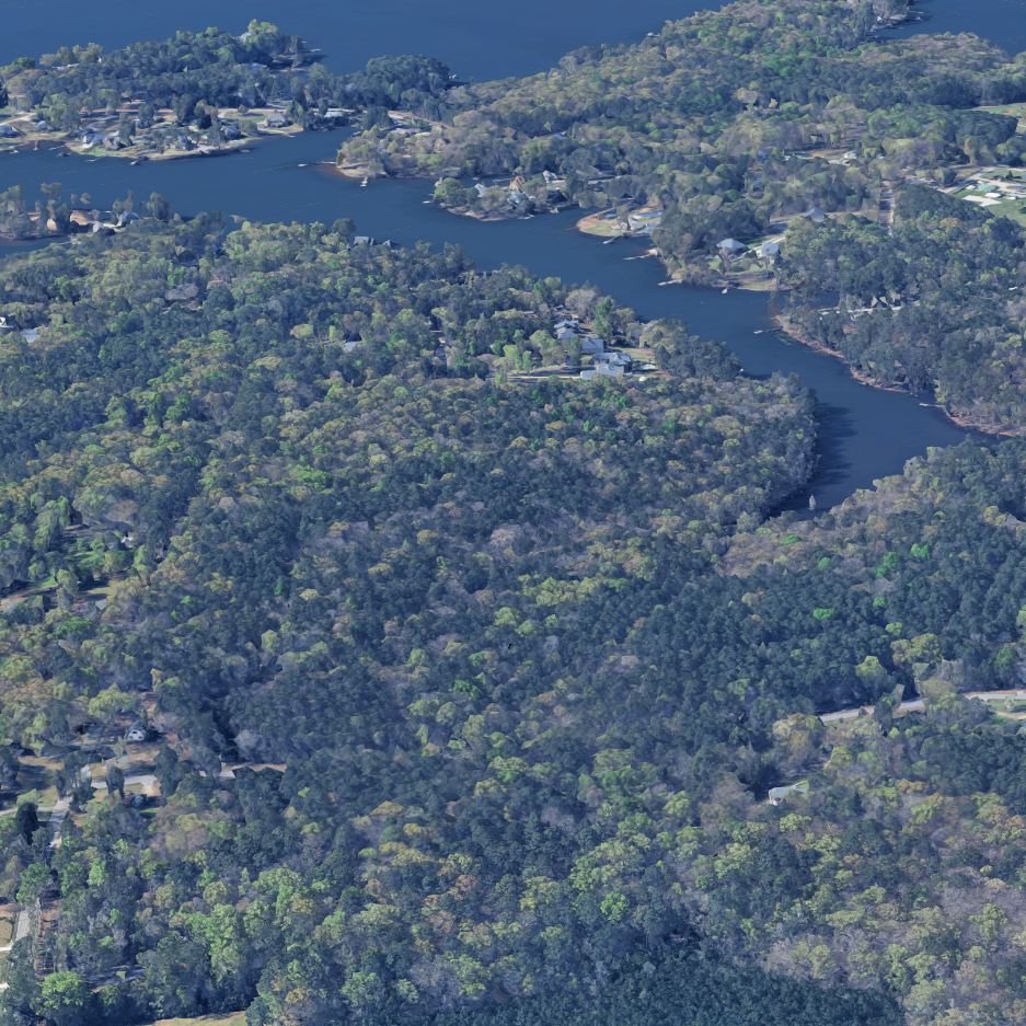 Aerial view of a winding river surrounded by dense green forest and residential neighborhoods.