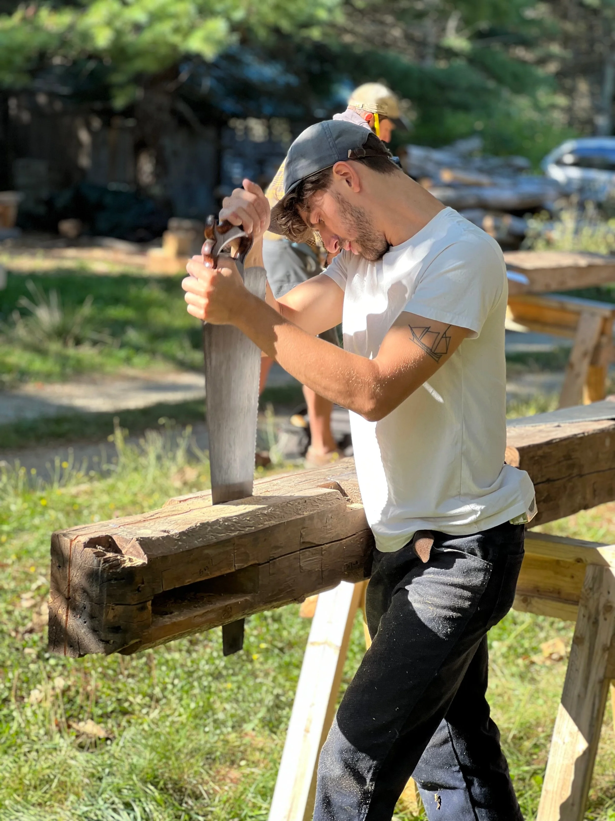 Nevan Carling sawing a timber for a repair at Joshua Klein's house restoration project in Blue Hill, Maine