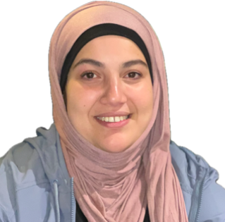 Portrait of a woman wearing a light pink hijab and a light blue jacket, smiling at the camera.