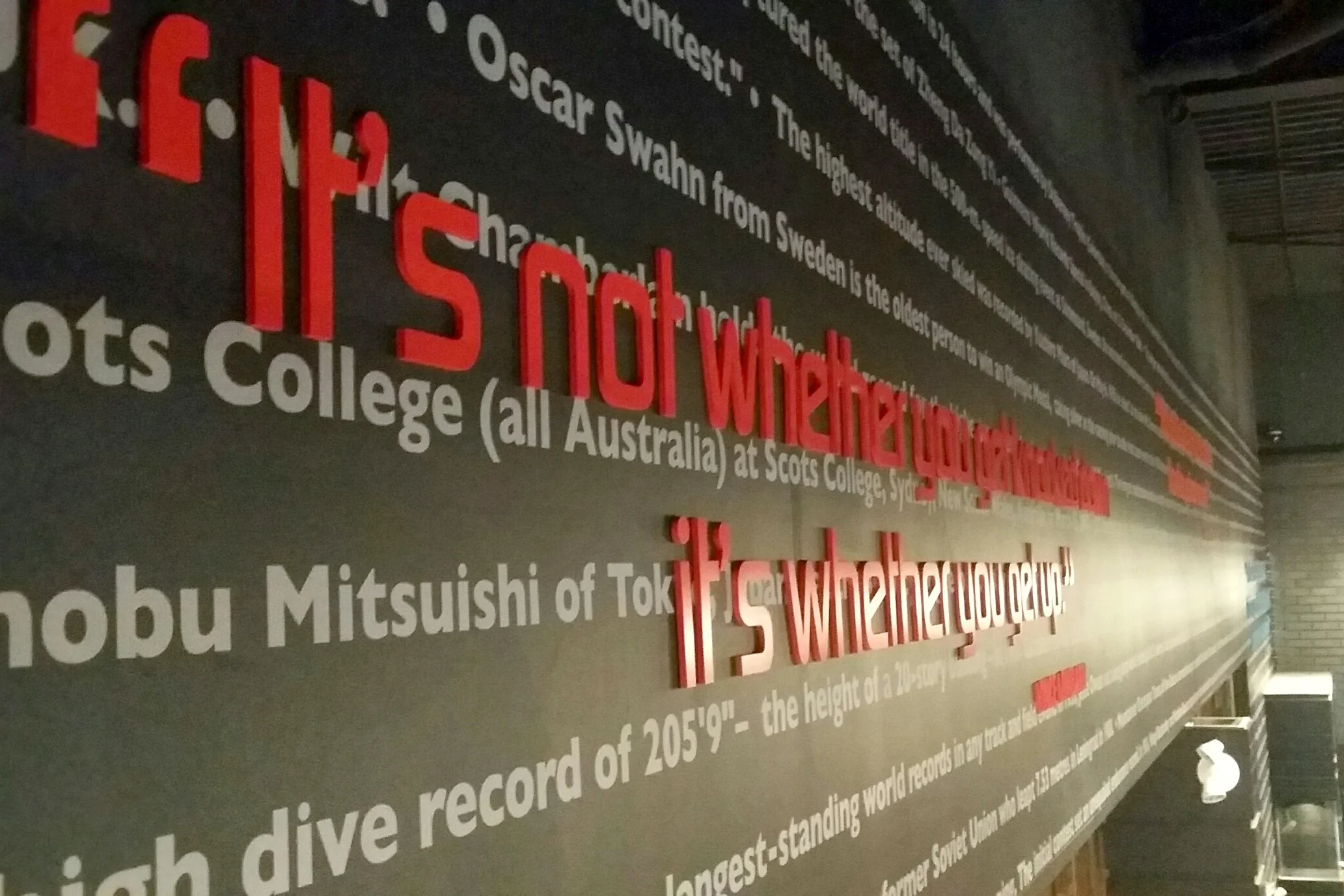 ~A wall display with large red 3D text asking 'Is not whether you can dive, but where you dive'. Smaller text provides additional information about famous Scottish and Japanese divers, their achievements, and world records.
