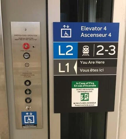~Elevator and floor directory sign for Elevator 4, L2, and L1 with accessibility and fire safety information.