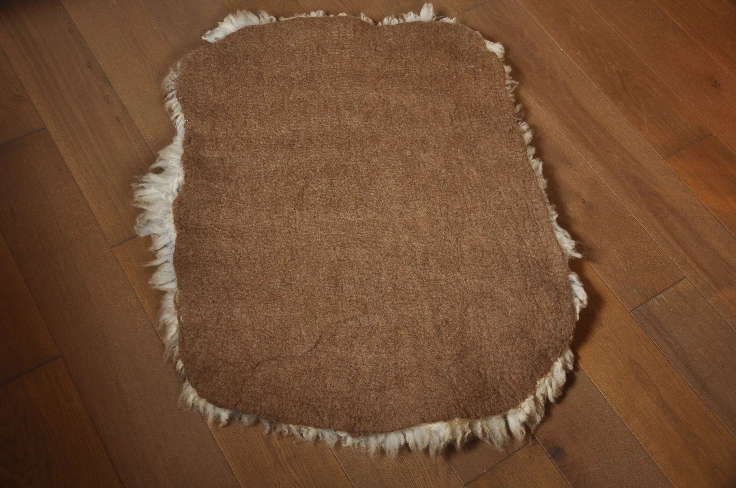 back of felted rug on floor