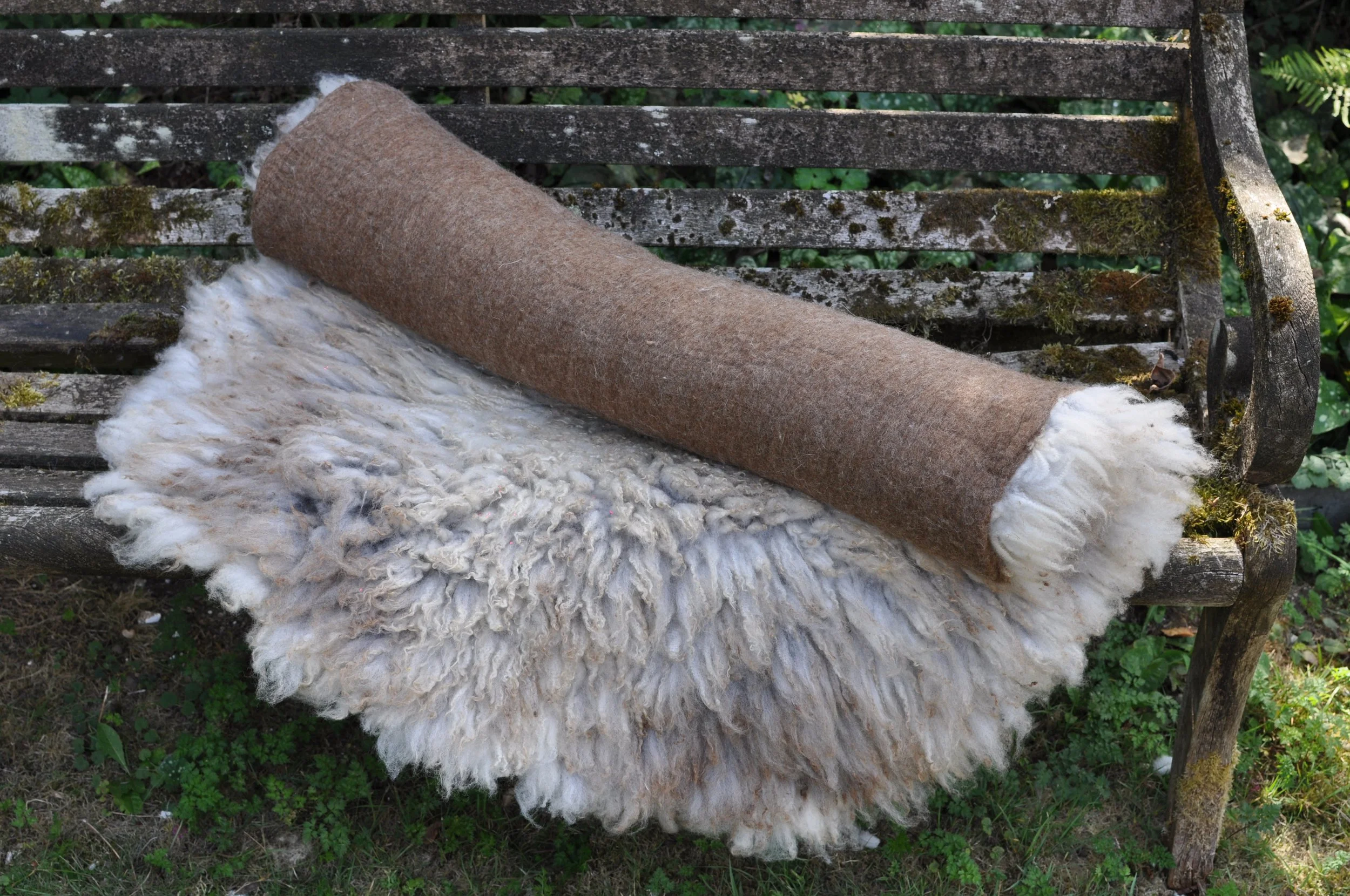 Rolled felted rug on a bench outside