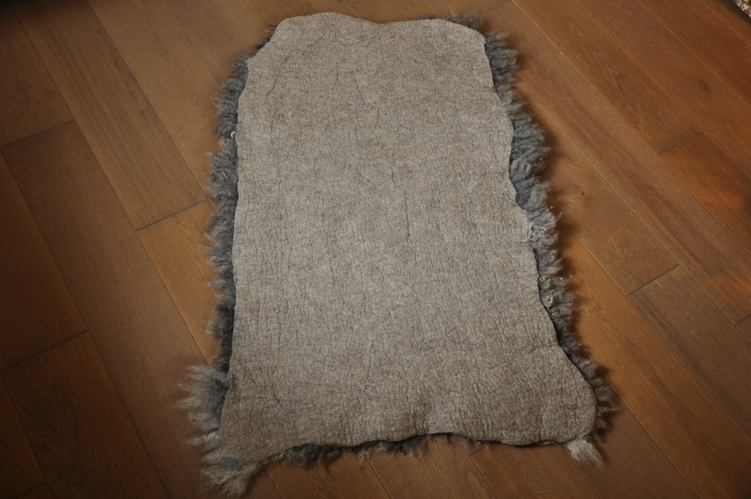 back of felted rug on floor