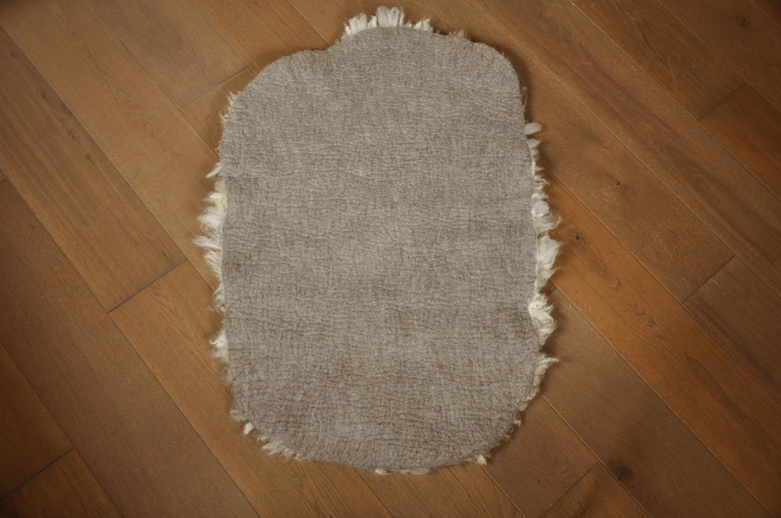 back of felted rug on floor