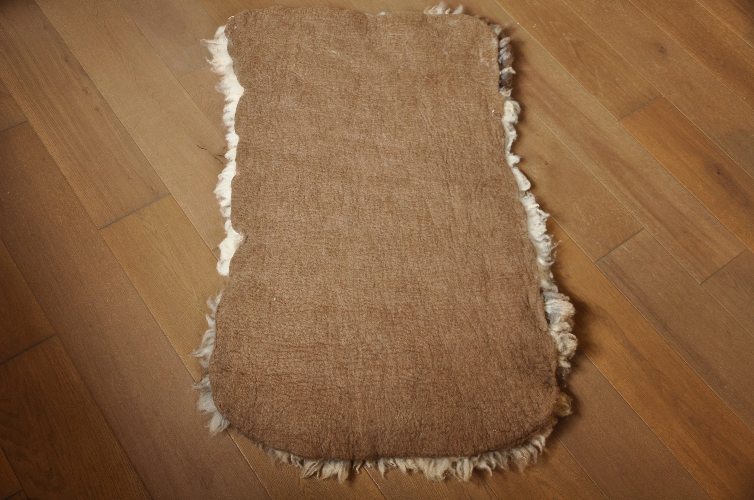 back of felted rug on floor