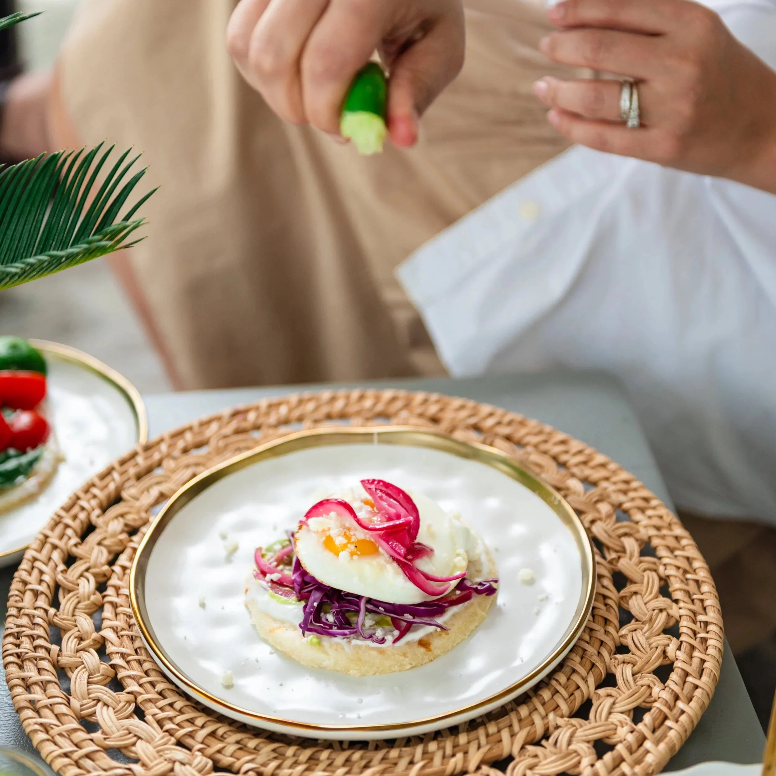 Gluten-free Yuki Arepa topped with shredded cabbage, soft-boiled egg, and pickled onions, served with a squeeze of fresh lime.