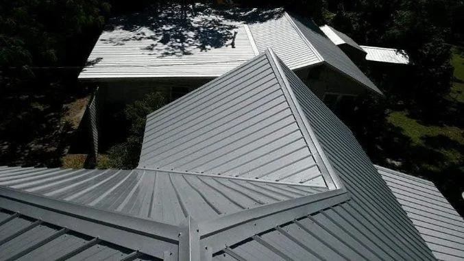 Complex standing seam metal roof installation with multiple intersecting ridges completed by Tindall Construction.